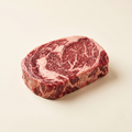 Raw marbled ribeye steak — Alberta grass-fed beef