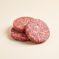 Raw Kobe-style burger patties with steak marbling