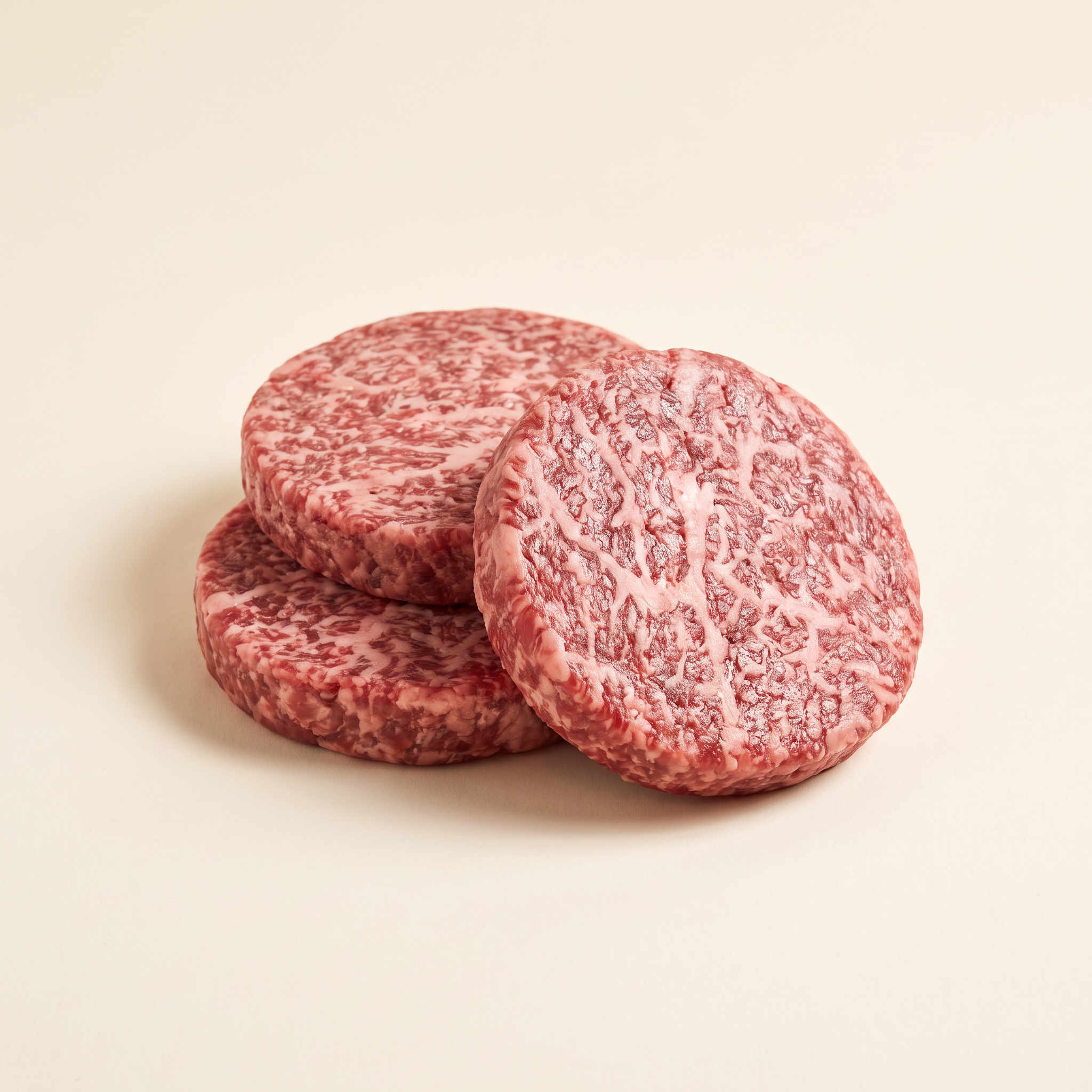 Raw Kobe-style burger patties with steak marbling